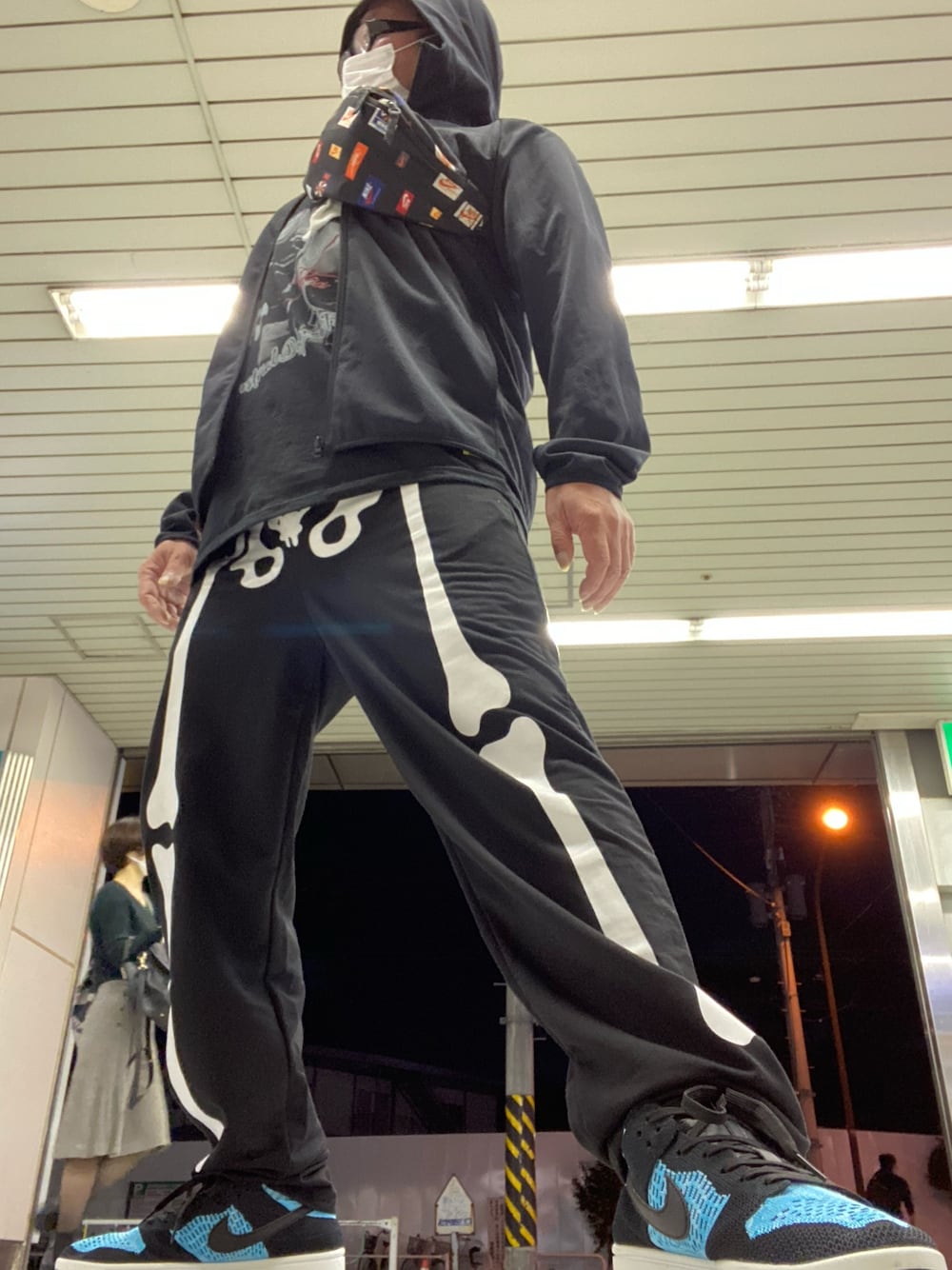 ブラック系のスウェットパンツ、ブルー系のスニーカーを着用したメンズの秋コーディネートの1枚目の写真