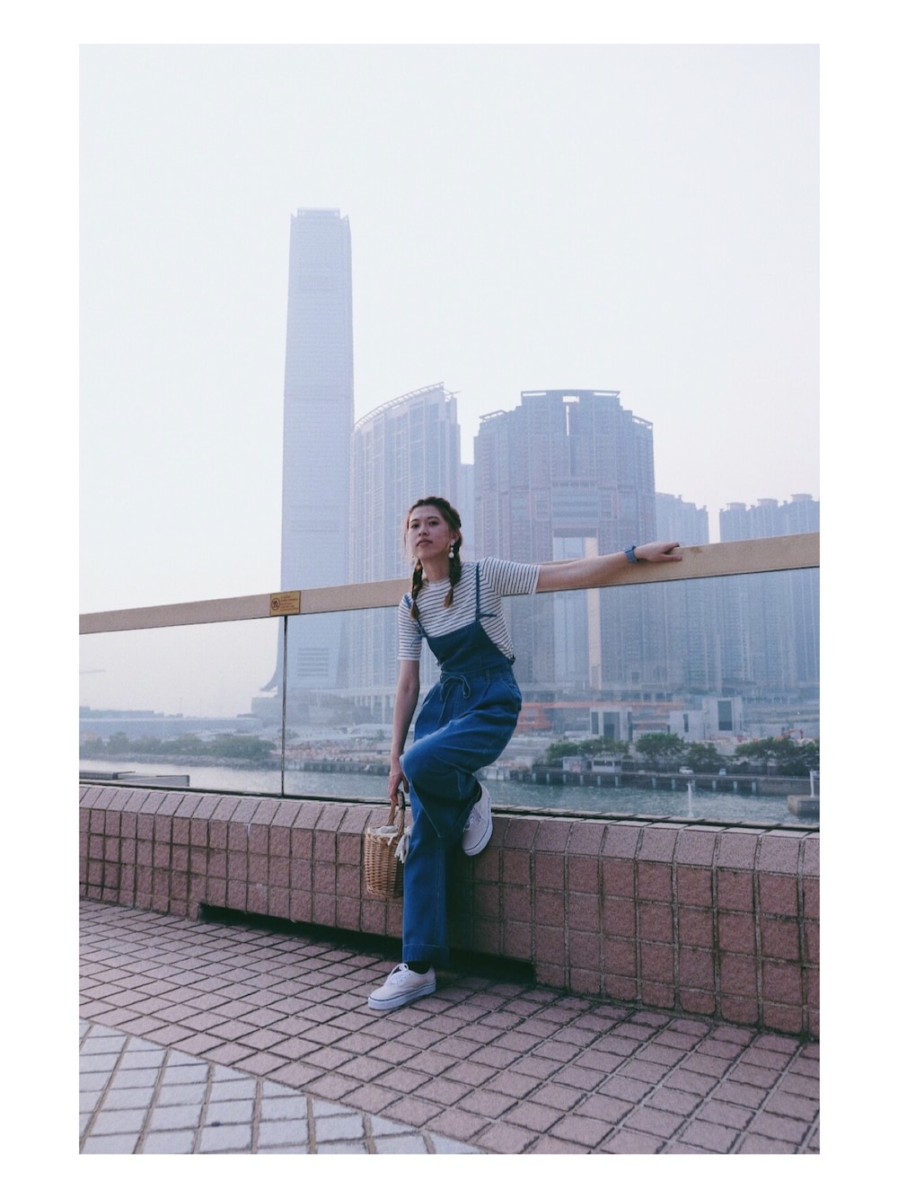 ブルー系のサロペット/オーバーオール、ベージュ系のかごバッグ、ホワイト系のシューズを着用したレディースの夏コーディネートの1枚目の写真