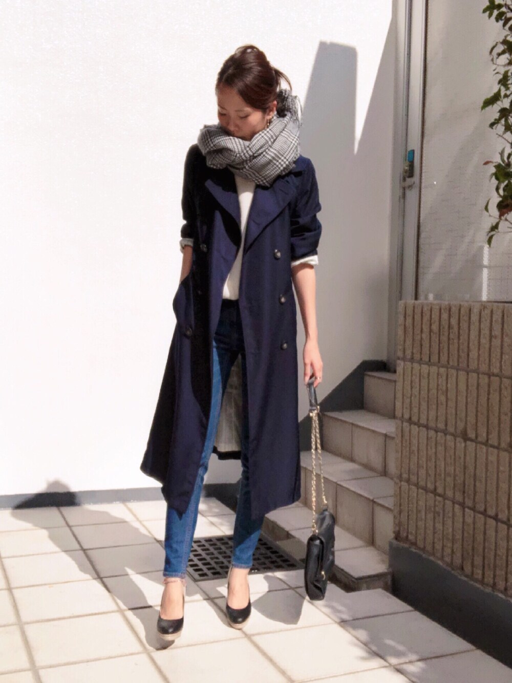 ホワイト系のTシャツ/カットソー、ブルー系のトレンチコート、ブルー系のデニムパンツを着用したレディースの秋コーディネートの1枚目の写真