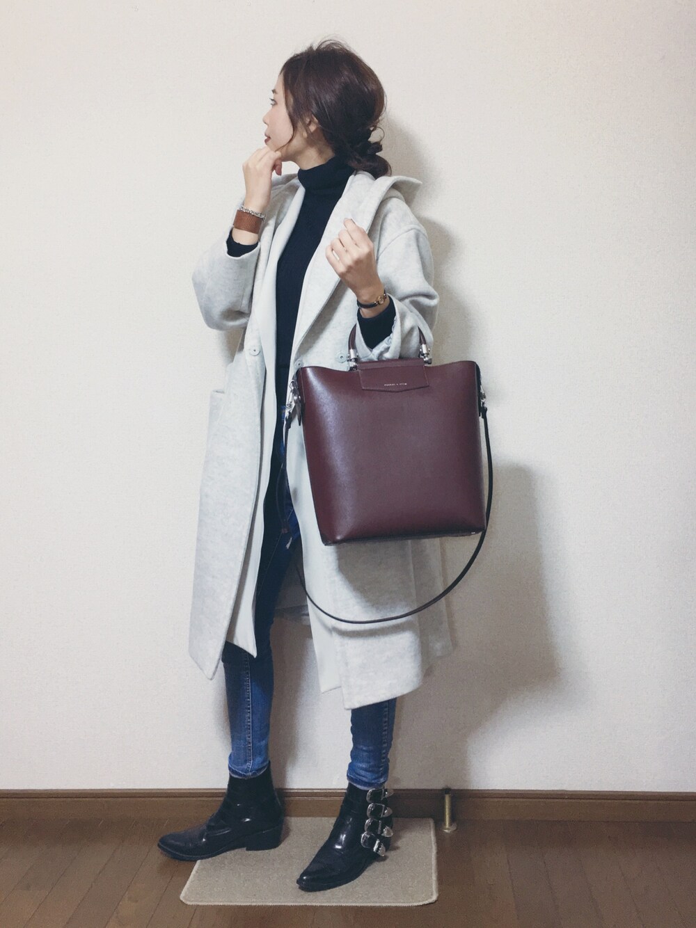 ブラック系のニット/セーター、レッド系のトートバッグ、ホワイト系のその他アウターを着用したレディースの冬コーディネートの1枚目の写真