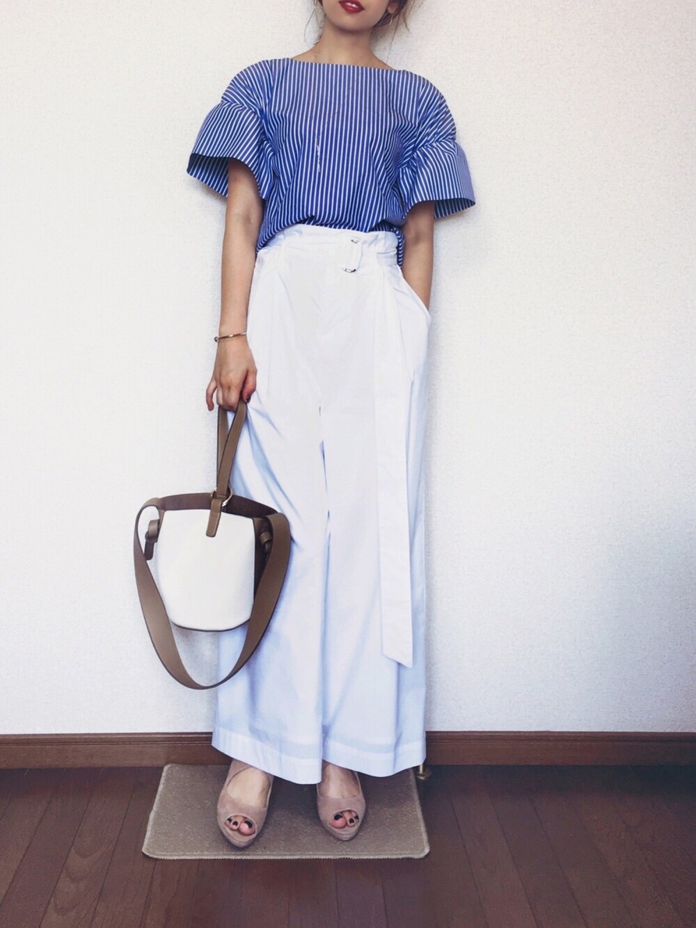 ブルー系のシャツ/ブラウス、ホワイト系のパンツ、ベージュ系のショルダーバッグを着用したレディースの夏コーディネートの1枚目の写真
