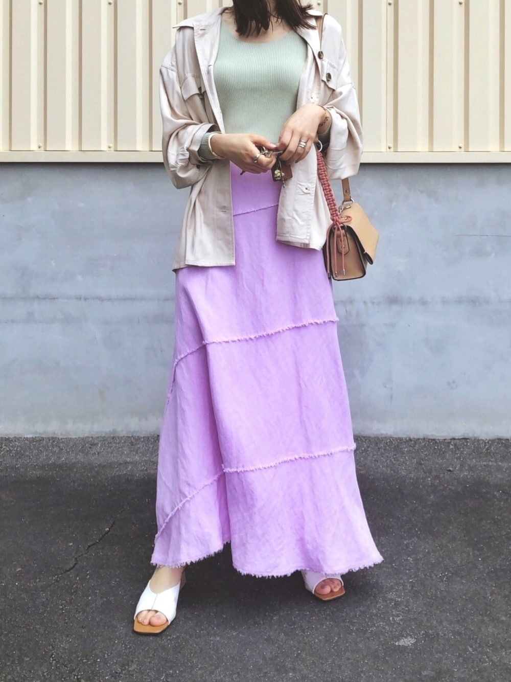 グリーン系のニット/セーター、ベージュ系のシャツ/ブラウス、ベージュ系のショルダーバッグを着用したレディースの春コーディネートの1枚目の写真