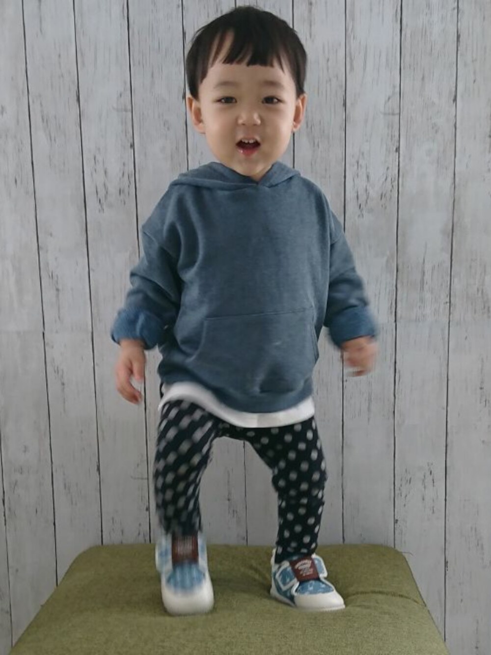 ピンク系のパーカー、ブルー系のスニーカー、ブラック系のその他パンツを着用したキッズの春コーディネートの1枚目の写真
