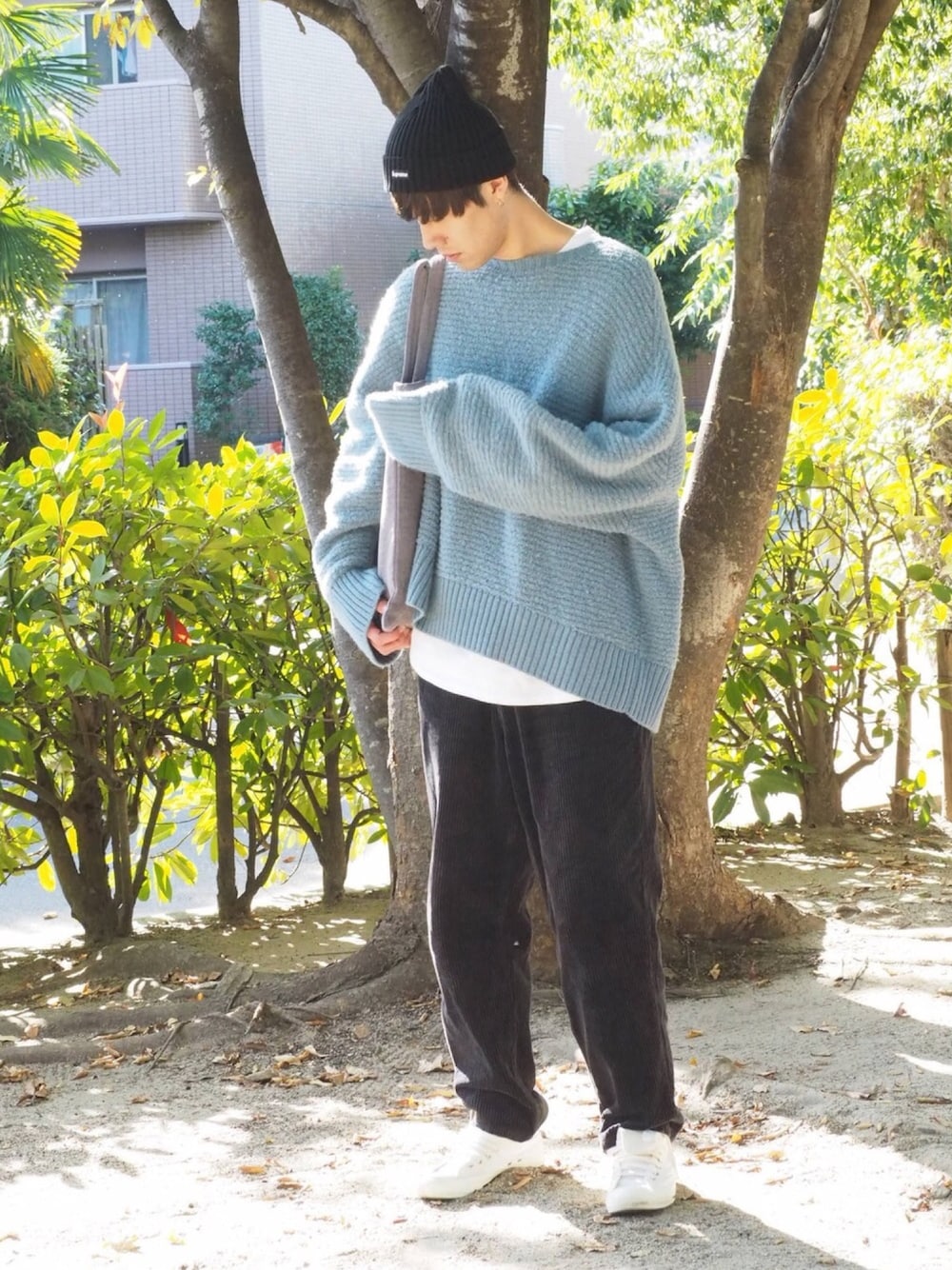 ブルー系のニット/セーター、ホワイト系のTシャツ/カットソー、ホワイト系のスニーカーを着用したメンズの秋コーディネートの1枚目の写真