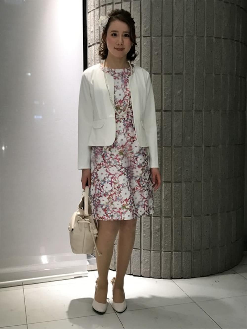 ピンク系のワンピース、ホワイト系のノーカラージャケットを着用したレディースの春コーディネートの1枚目の写真