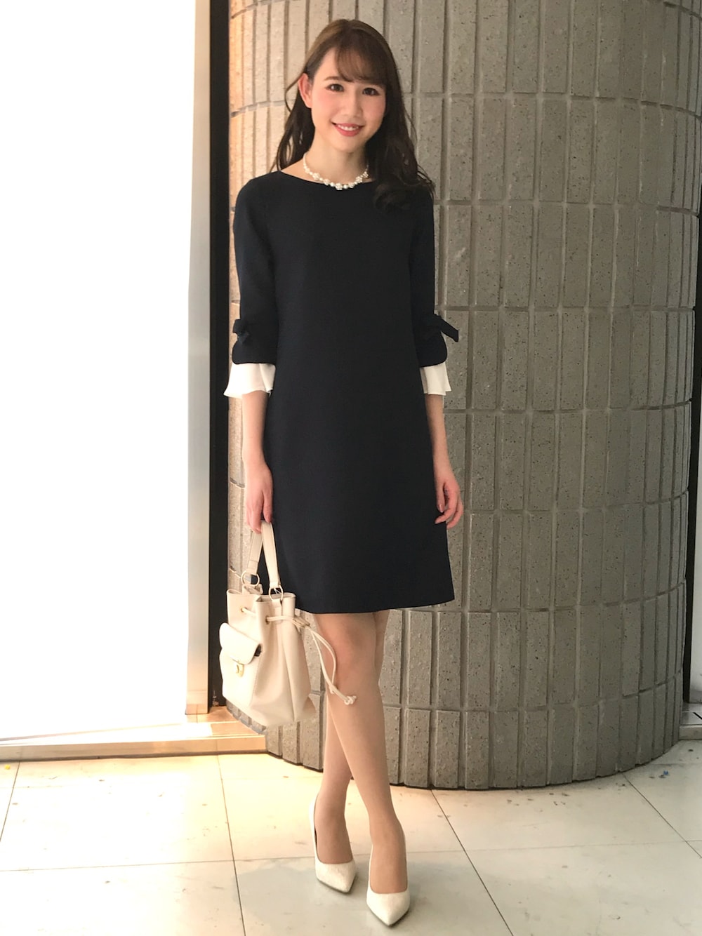 ブルー系のワンピースを着用したレディースの春コーディネートの1枚目の写真