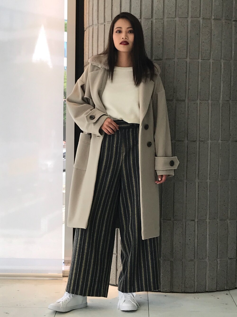 ベージュ系のチェスターコートを着用したレディースの秋コーディネートの1枚目の写真