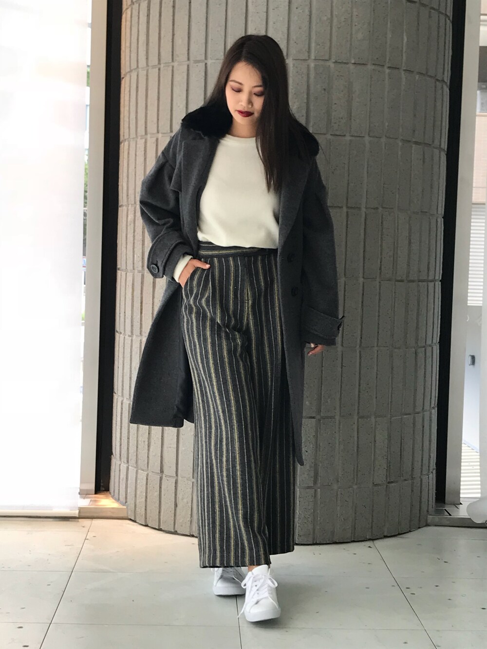 グレー系のチェスターコートを着用したレディースの秋コーディネートの1枚目の写真