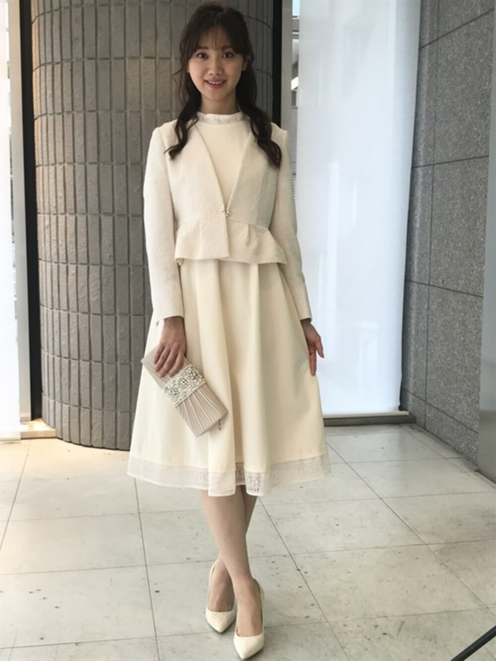 ホワイト系のワンピース、ホワイト系のノーカラージャケットを着用したレディースの冬コーディネートの1枚目の写真