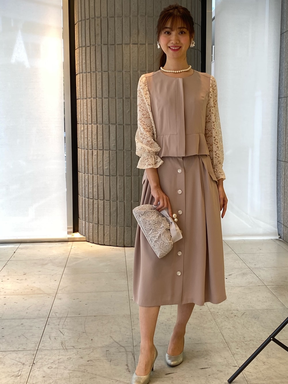 ベージュ系のノーカラージャケット、ベージュ系のスカートを着用したレディースの春コーディネートの1枚目の写真