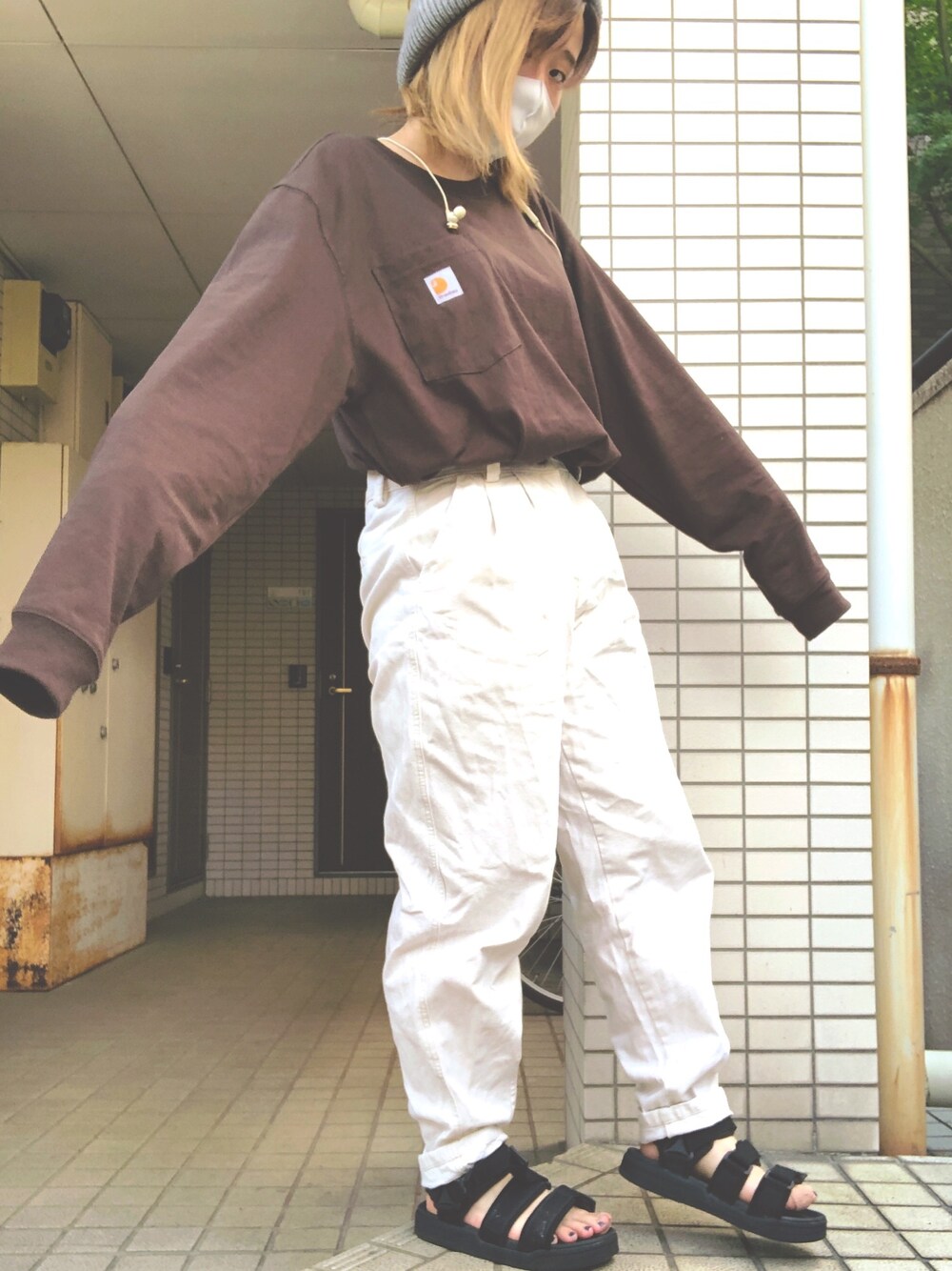 ブラウン系のTシャツ/カットソー、ホワイト系のパンツ、ブラック系のサンダルを着用したレディースの秋コーディネートの1枚目の写真