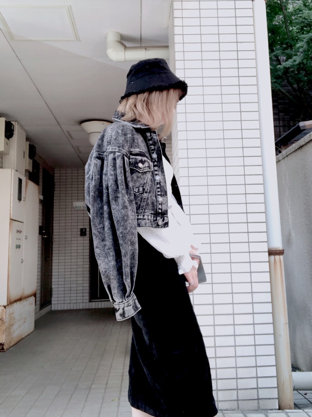 ブラック系のデニムジャケット、ブラック系の帽子を着用したレディースの秋コーディネートの1枚目の写真