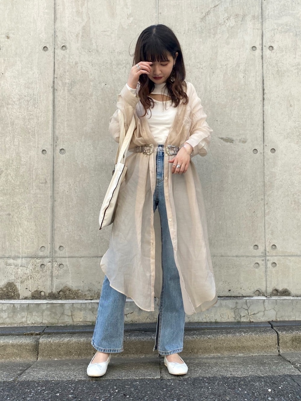 ベージュ系のシャツ/ブラウス、ホワイト系のTシャツ/カットソー、ブルー系のデニムパンツを着用したレディースの春コーディネートの1枚目の写真