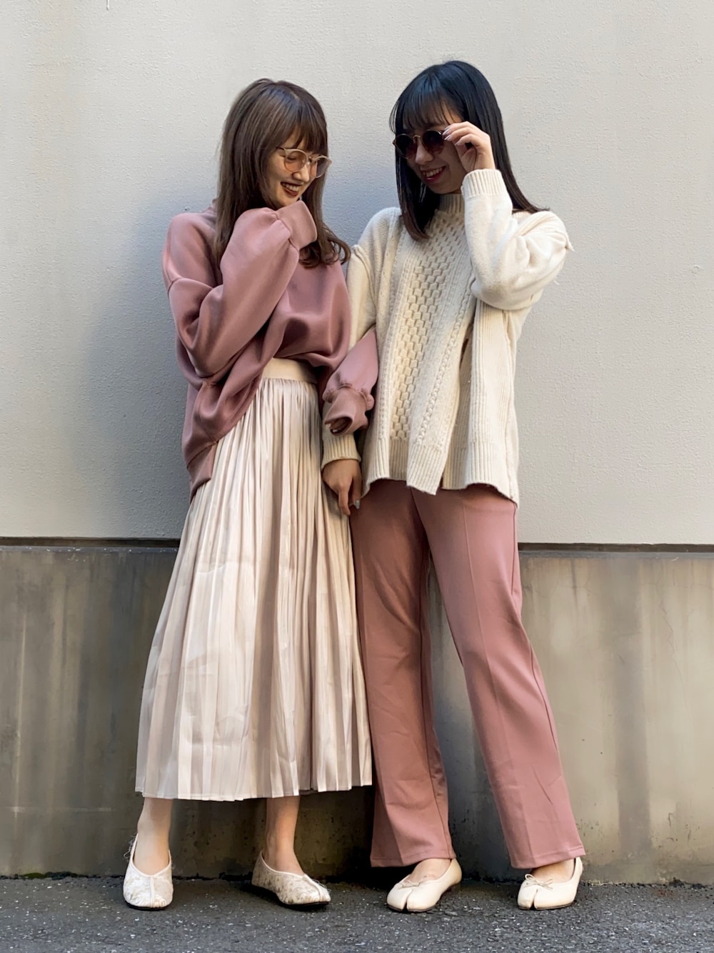 ピンク系のスウェット、ベージュ系のパンプス、ホワイト系のスカートを着用したレディースの秋コーディネートの1枚目の写真