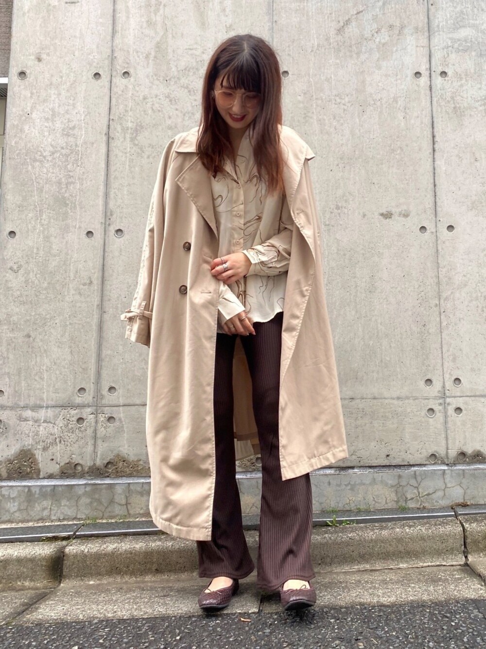 ベージュ系のトレンチコート、ホワイト系のシャツ/ブラウス、ブラウン系のその他パンツを着用したレディースの春コーディネートの1枚目の写真