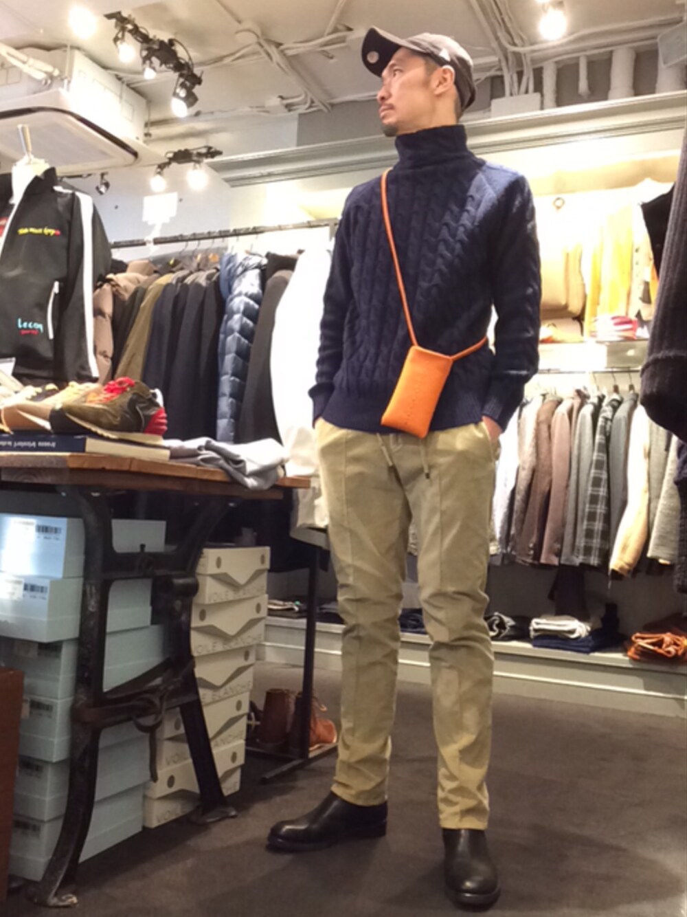 ブルー系のニット/セーター、ベージュ系のその他パンツ、ブラック系のブーツを着用したメンズの秋コーディネートの1枚目の写真