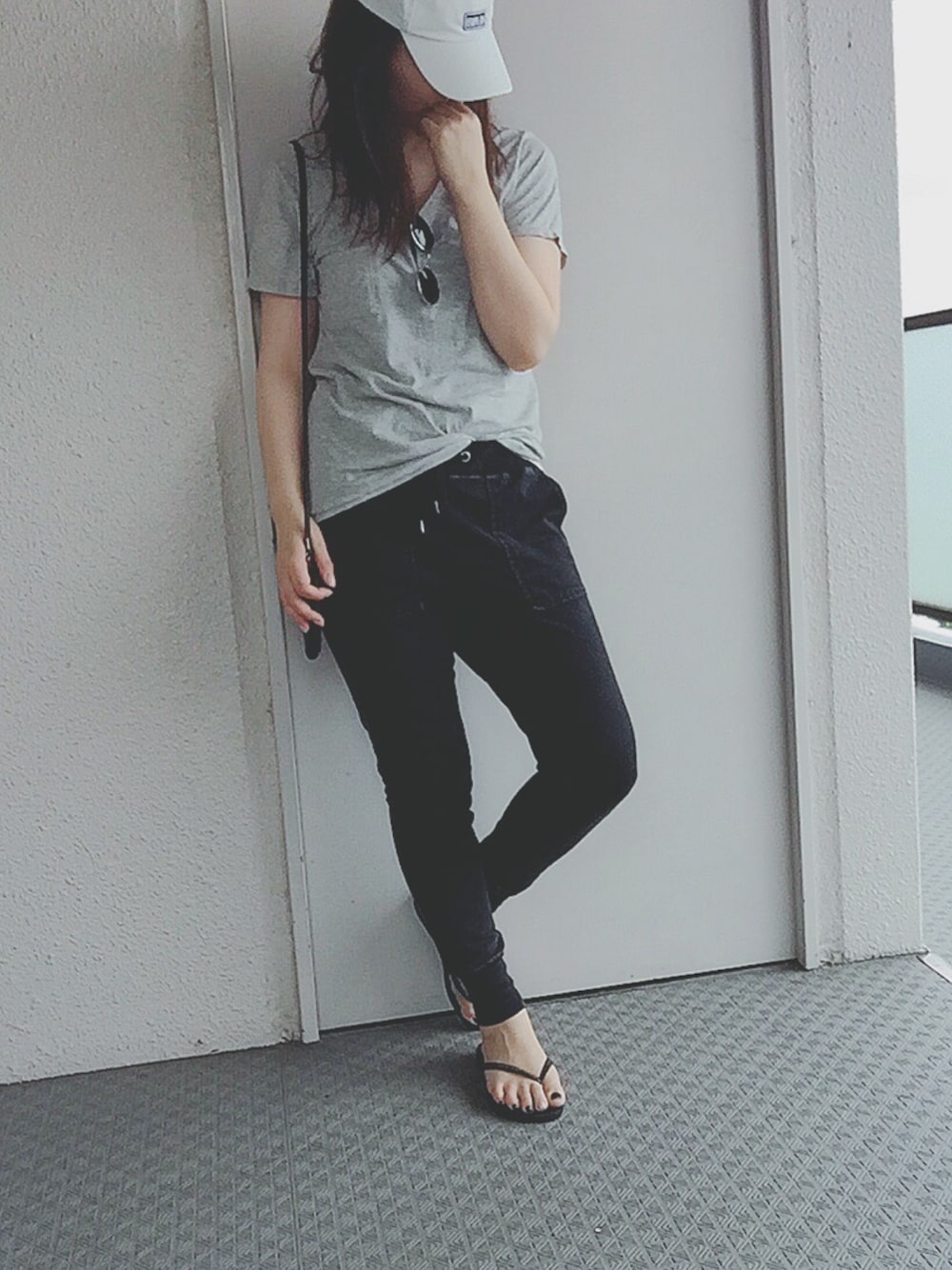 グレー系のTシャツ/カットソー、ブラック系のパンツ、ブラック系のビーチサンダルを着用したレディースの夏コーディネートの1枚目の写真