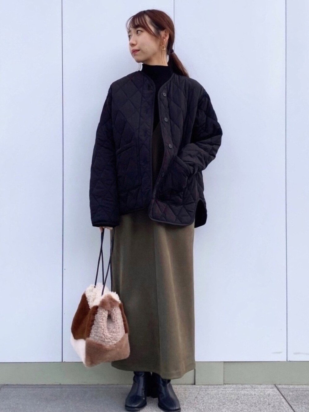 ブラウン系のショルダーバッグ、グリーン系のワンピース、ホワイト系のニット/セーターを着用したレディースの冬コーディネートの1枚目の写真