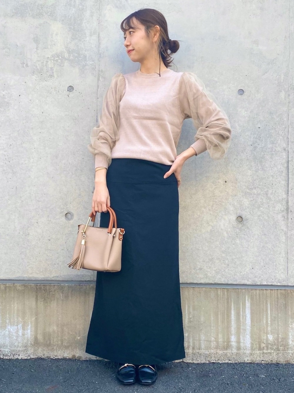 ベージュ系のニット/セーター、ブラック系のスカート、ベージュ系のトートバッグを着用したレディースの冬コーディネートの1枚目の写真