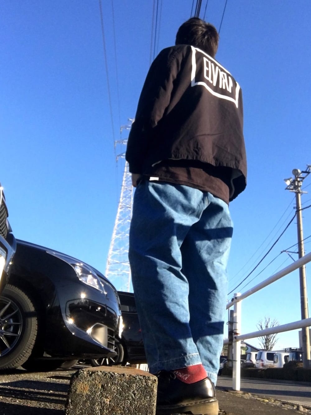 ブラック系のノーカラージャケット、ブラック系のTシャツ/カットソー、ブルー系のデニムパンツを着用したメンズの冬コーディネートの1枚目の写真