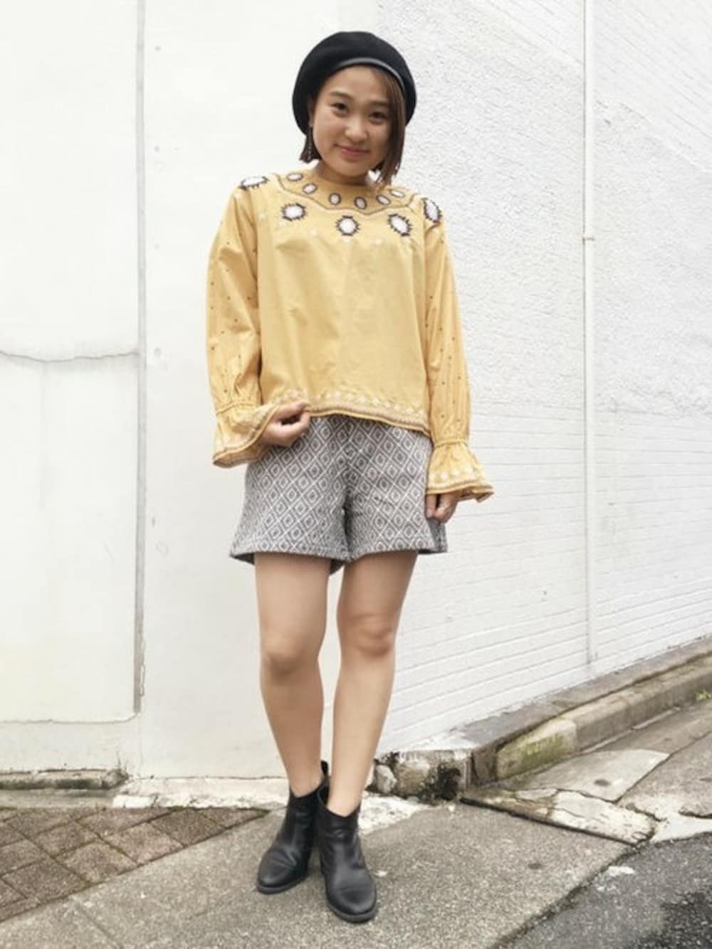 イエロー系のシャツ/ブラウス、ブルー系のその他パンツ、ブラック系のハンチング/ベレー帽を着用したレディースの秋コーディネートの1枚目の写真