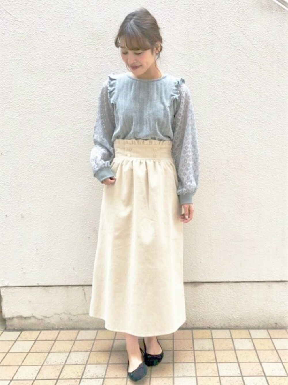 ブルー系のニット/セーター、ベージュ系のスカートを着用したレディースの秋コーディネートの1枚目の写真