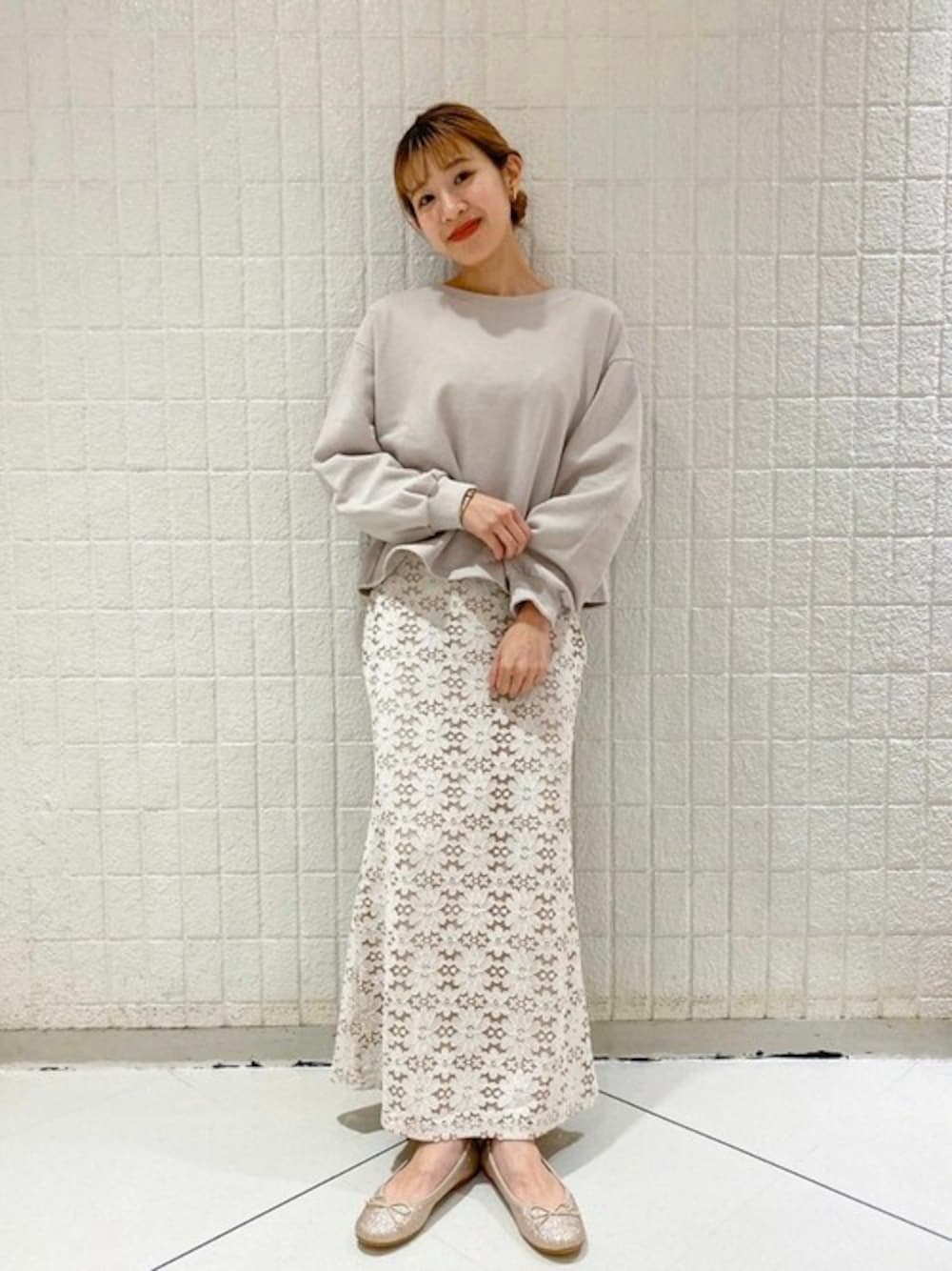 ホワイト系のスカート、ピンク系のスウェット、ゴールド系のバレエシューズを着用したレディースの冬コーディネートの1枚目の写真