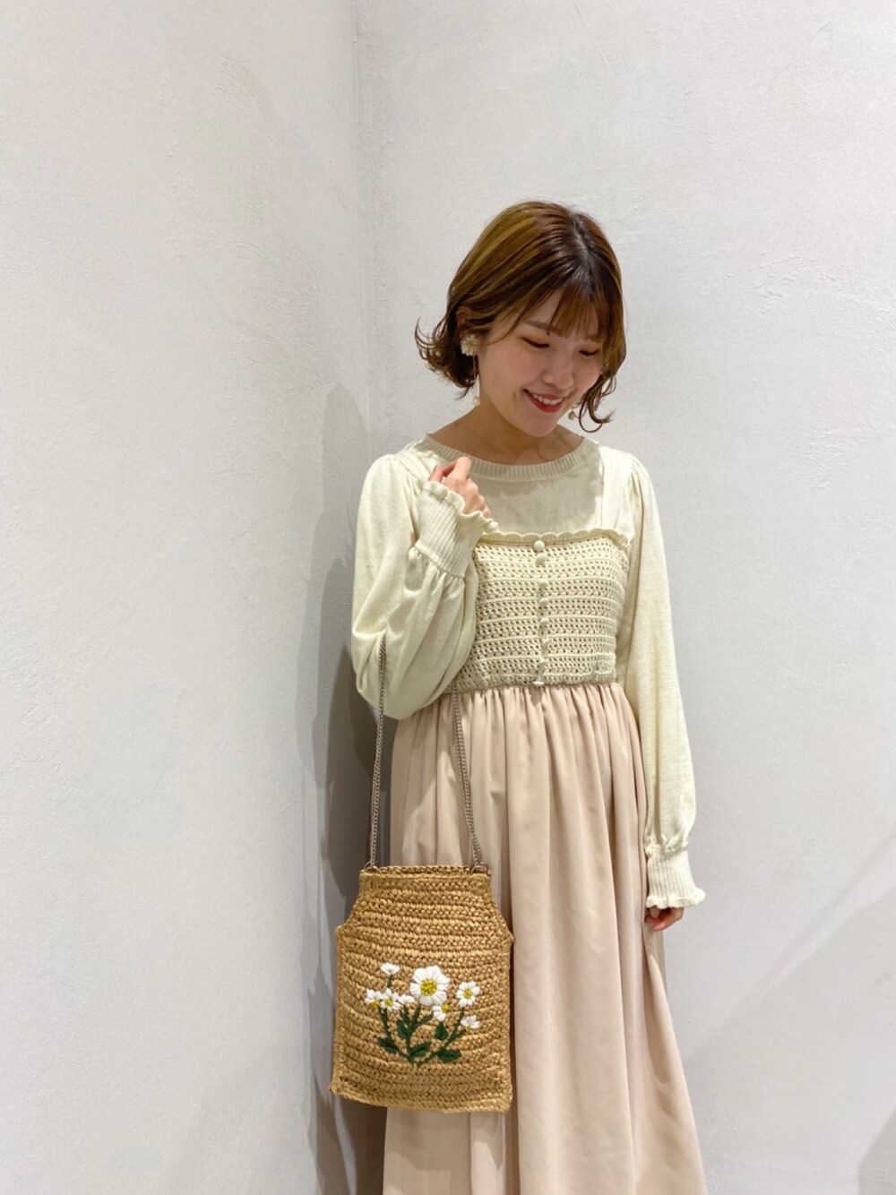 ホワイト系のワンピース、ホワイト系のニット/セーター、ホワイト系のショルダーバッグを着用したレディースの冬コーディネートの1枚目の写真