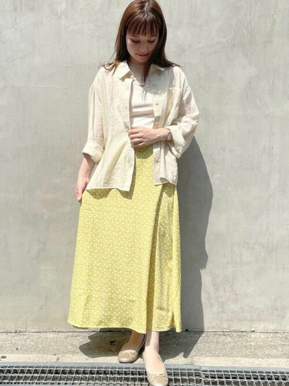 ホワイト系のシャツ/ブラウス、イエロー系のスカートを着用したレディースの春コーディネートの1枚目の写真