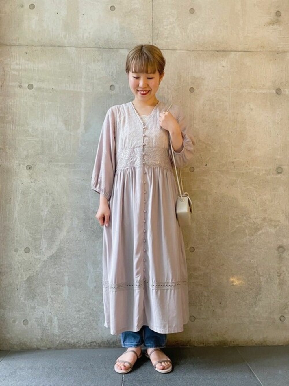 パープル系のワンピース、ホワイト系のショルダーバッグを着用したレディースの夏コーディネートの1枚目の写真