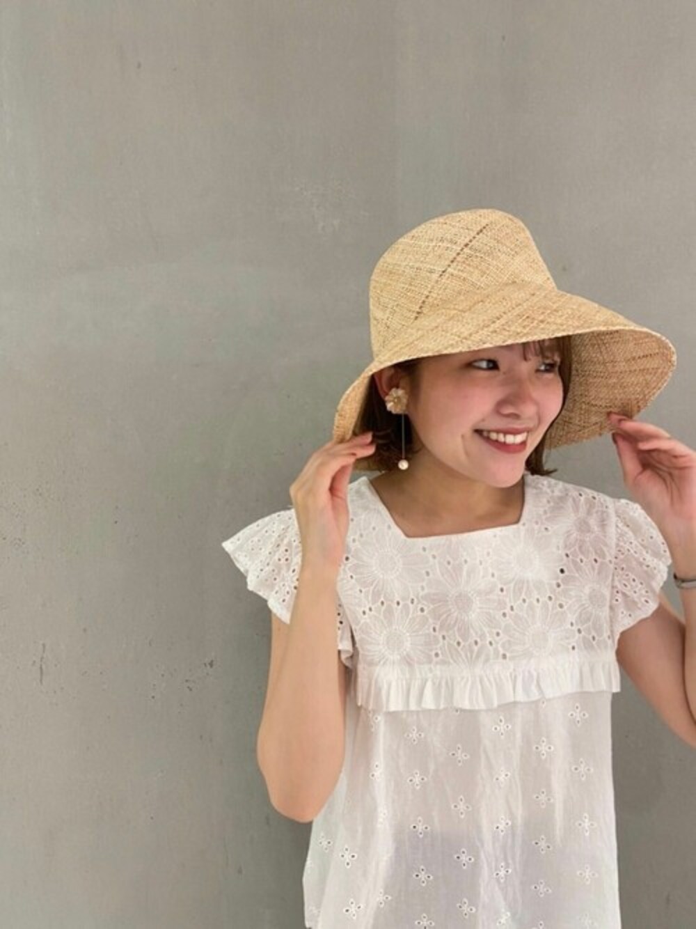 ベージュ系のハットを着用したレディースの夏コーディネートの1枚目の写真