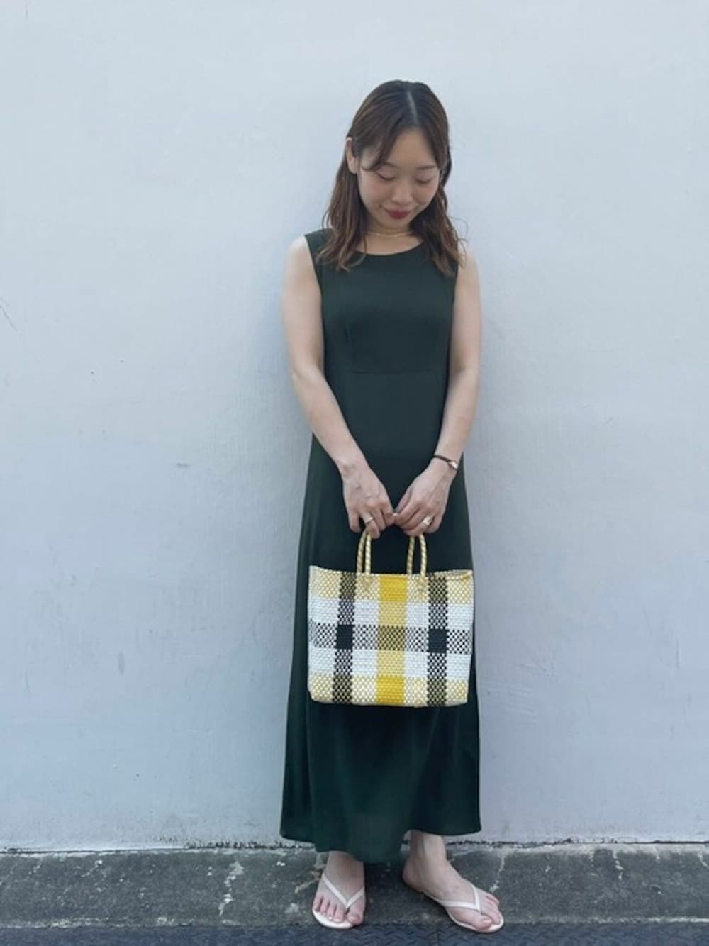 イエロー系のかごバッグを着用したレディースの夏コーディネートの1枚目の写真