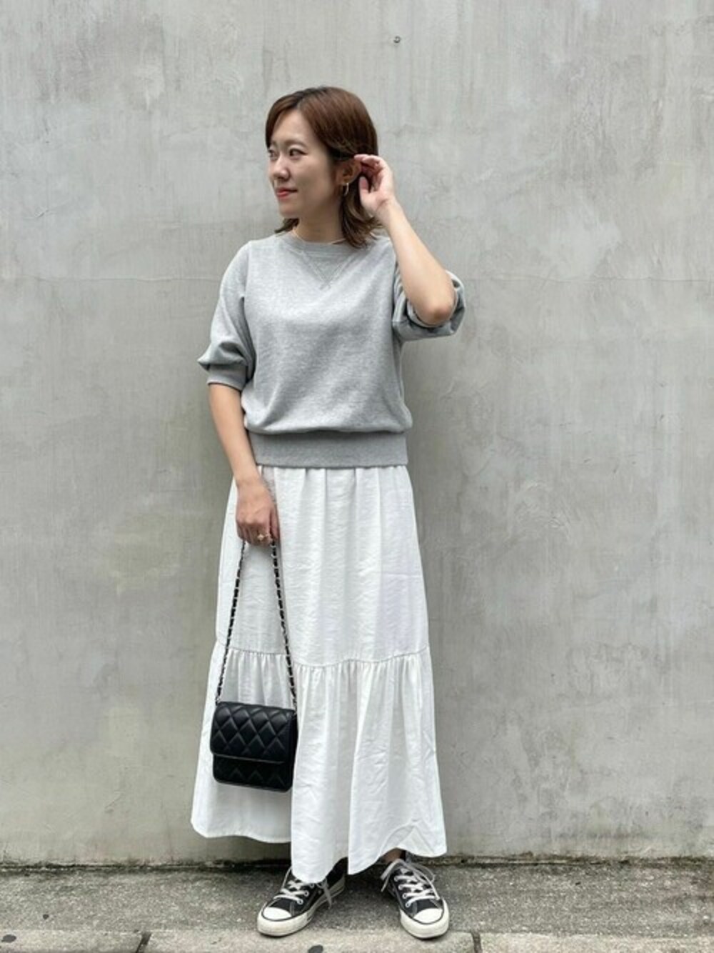 グレー系のスウェット、ブラック系のショルダーバッグを着用したレディースの夏コーディネートの1枚目の写真