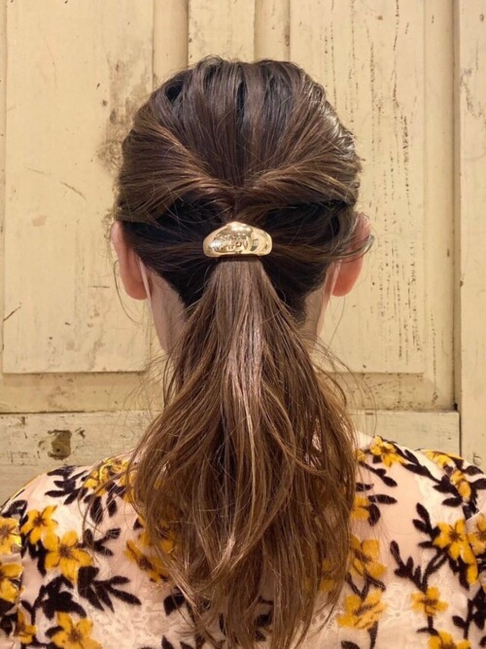 ゴールド系のヘアゴムを着用したレディースの秋コーディネートの1枚目の写真