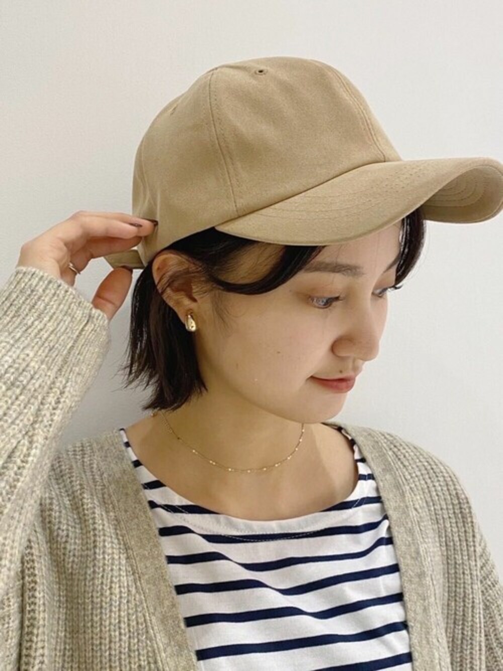 ベージュ系のキャップを着用したレディースの秋コーディネートの1枚目の写真