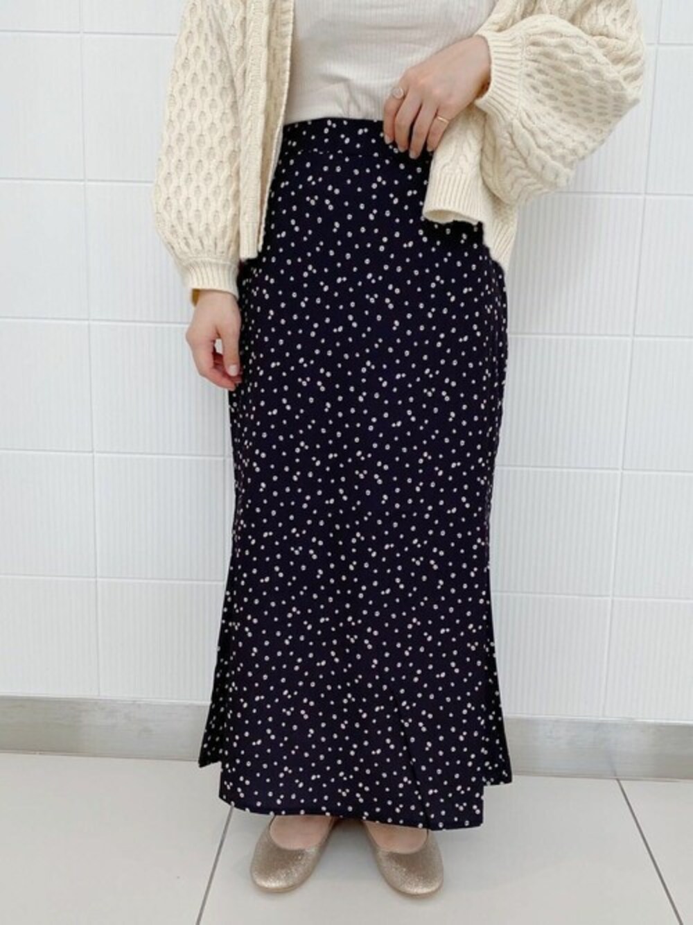 ブラック系のスカートを着用したレディースの秋コーディネートの1枚目の写真