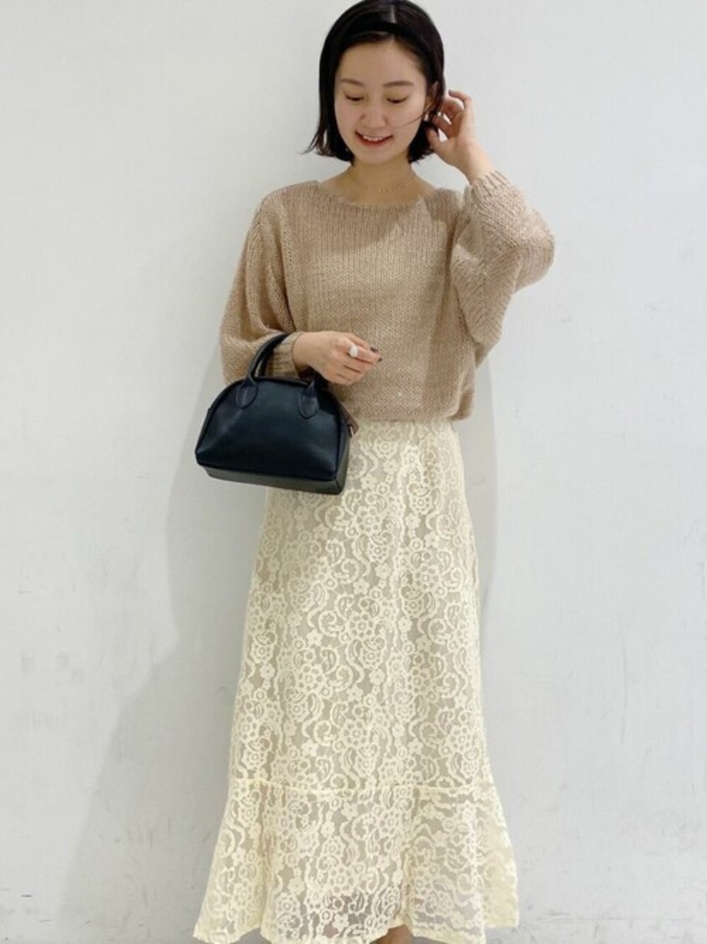 ホワイト系のスカート、ホワイト系のニット/セーターを着用したレディースの冬コーディネートの1枚目の写真