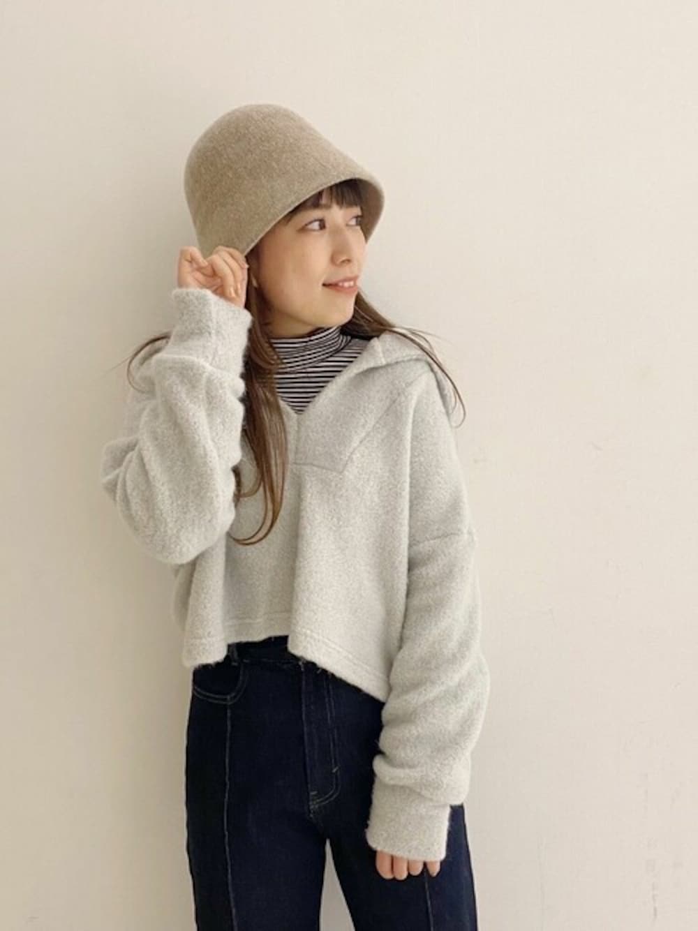 ホワイト系のニット/セーター、ベージュ系のハットを着用したレディースの冬コーディネートの1枚目の写真