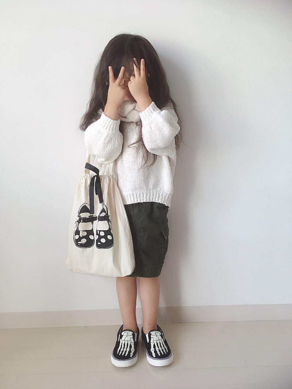 「ラブアンドピース2017、キッズコーデ、おんなのこ、GAP、スリッポン、カーゴスカート、ニット、トートバッグ、貧乏パーマ」｜「GAPのGap 蓄光ガイコツ スリッポンスニーカー（スニーカー、ブラック系）」を使った、* 𝚝𝚘𝚛𝚒𝚌𝚘𝚝*さん（キッズ・100cm）の秋コーディネートの1枚目の写真