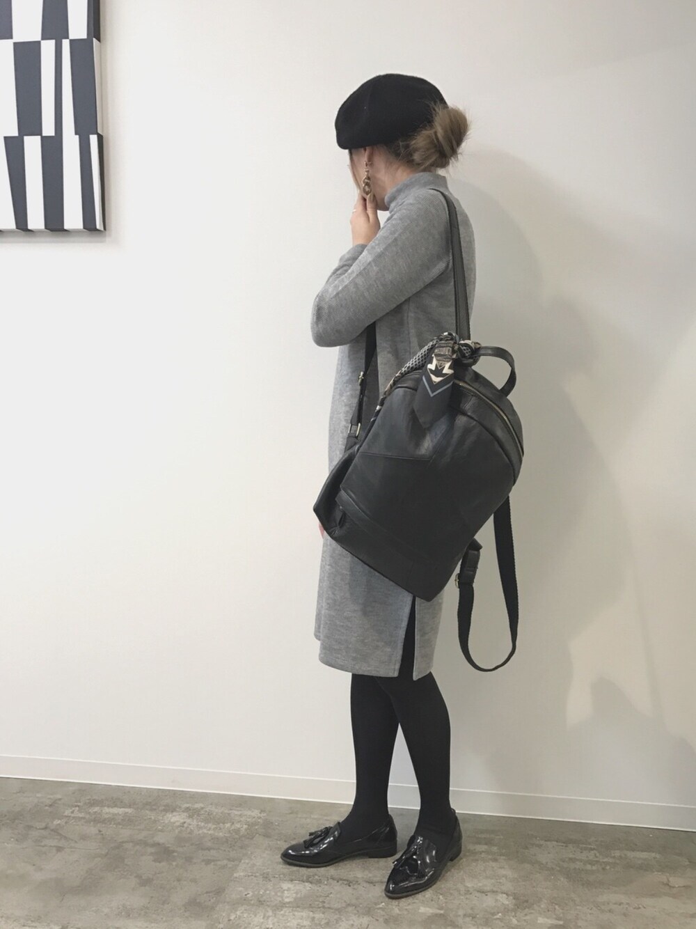 ブラック系のドレスシューズ、グレー系のワンピース、ブラック系のバックパック/リュックを着用したレディースの春コーディネートの1枚目の写真
