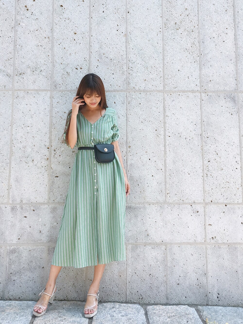 グリーン系のワンピース、ベージュ系のサンダル、ブラック系のバッグを着用したレディースの春コーディネートの1枚目の写真