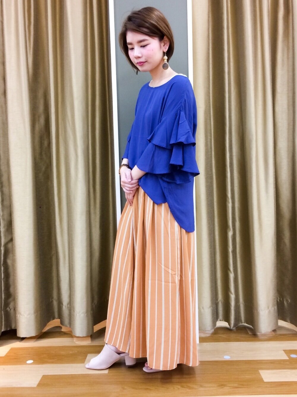 ブルー系のトップス、イエロー系のその他パンツを着用したレディースの春コーディネートの1枚目の写真