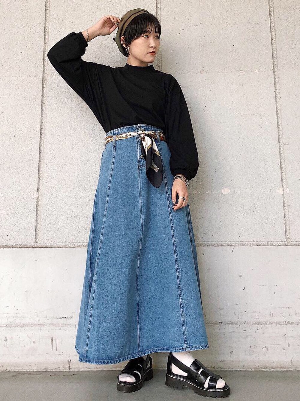 ブラック系のTシャツ/カットソー、ブルー系のデニムスカート、ブラック系のサンダルを着用したレディースの春コーディネートの1枚目の写真