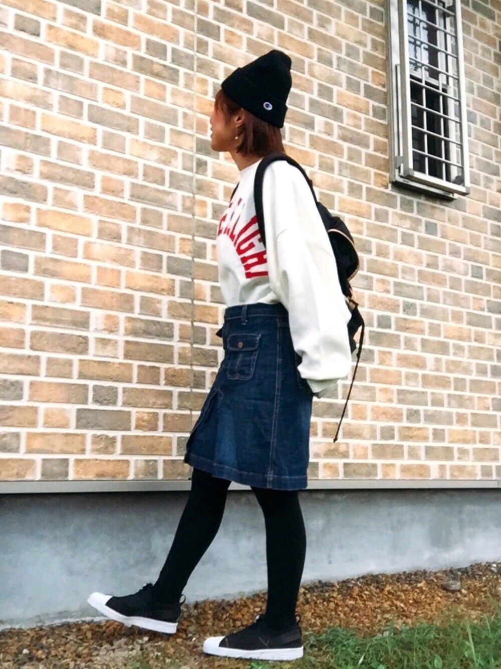 ホワイト系のTシャツ/カットソー、ブルー系のデニムスカート、ブラック系のバックパック/リュックを着用したレディースの秋コーディネートの1枚目の写真