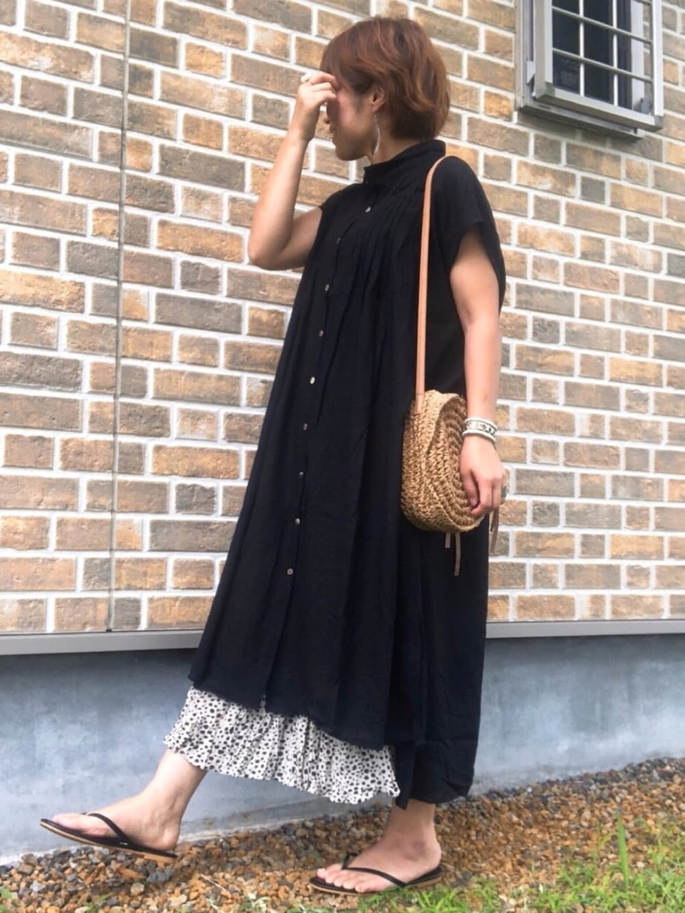 ブラック系のワンピース、ホワイト系のスカート、ベージュ系のショルダーバッグを着用したレディースの春コーディネートの1枚目の写真