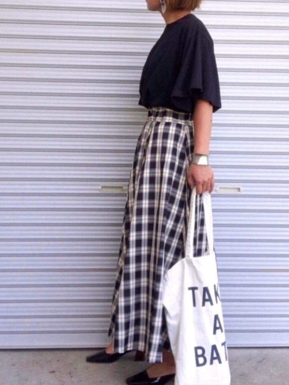 ブラック系のTシャツ/カットソー、ブラック系のスカート、ホワイト系のトートバッグを着用したレディースの秋コーディネートの1枚目の写真