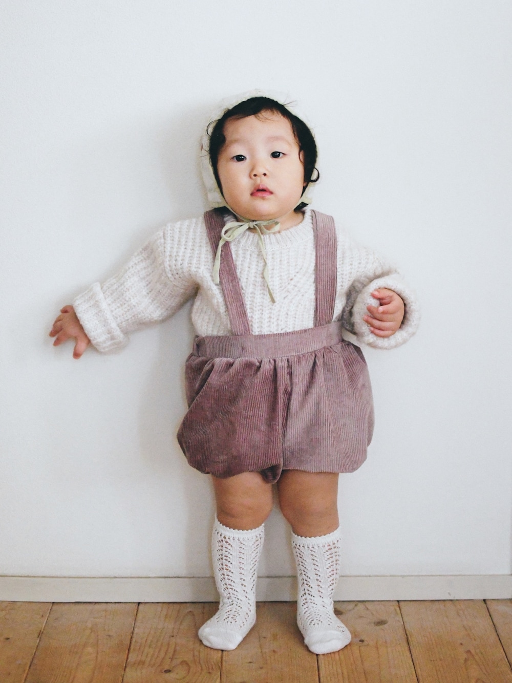 「baby、ボンネット、ケーブルニット、サスペンダー、ブルマ、1歳、1歳6ヶ月、赤ちゃんコーデ、むすめ服、コーデュロイ」｜「Apolina Kidsの  JONI BONNET- ALABASTER（帽子、ベージュ系）」を使った、Kちゃんさん（キッズ・80cm）の冬コーディネートの1枚目の写真