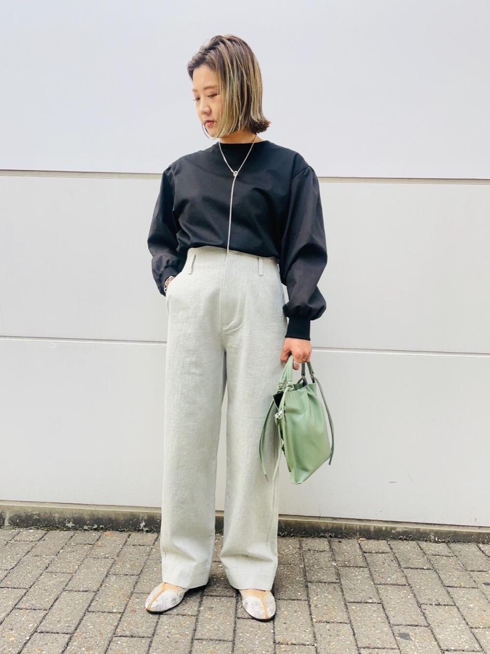 グリーン系のショルダーバッグ、ブルー系のデニムパンツ、ブラック系のTシャツ/カットソーを着用したレディースの冬コーディネートの1枚目の写真