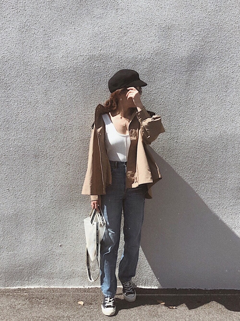 ベージュ系のジャケット/アウター、ホワイト系のトップス、ブルー系のデニムパンツを着用したレディースの秋コーディネートの1枚目の写真