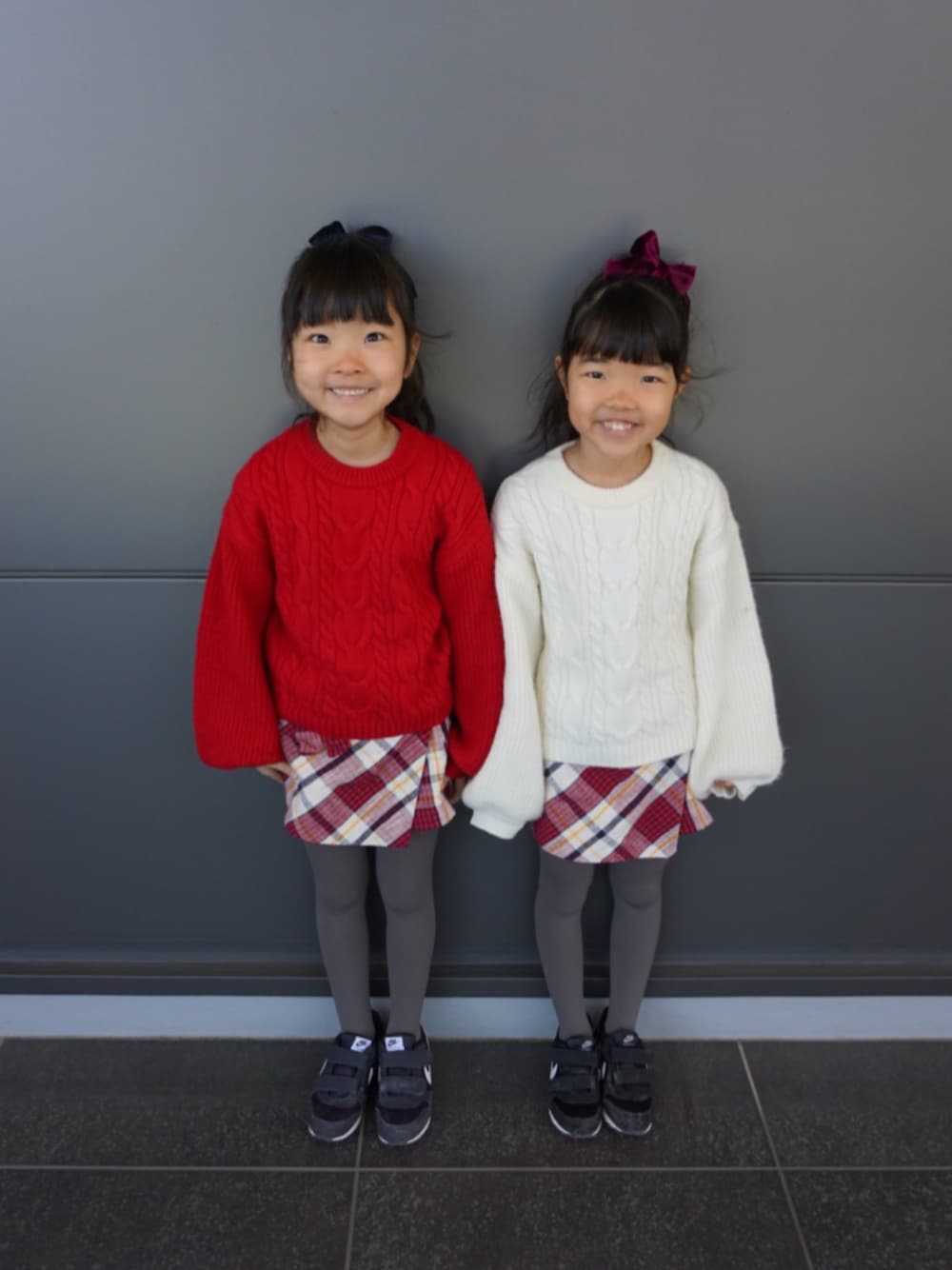「プチプラコーデ、双子コーデ、色違いコーデ、ナイキ、タイツ×スニーカー、ZARA、チェックスカート、おそろいコーデ、春」｜「ikkaのアイテム（ニット/セーター、レッド系）」を使った、A♡K♡Fさん（キッズ・120cm）の春コーディネートの1枚目の写真